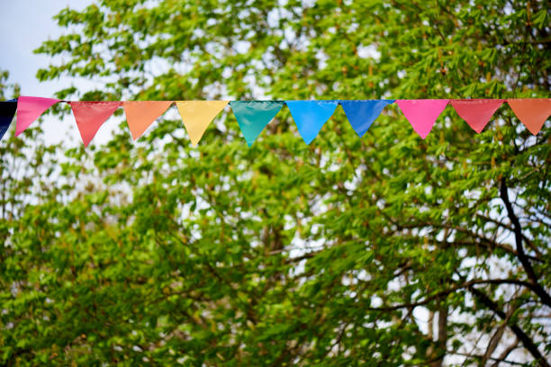 istock Colored flags on a background of green trees and the sky. 1319780401