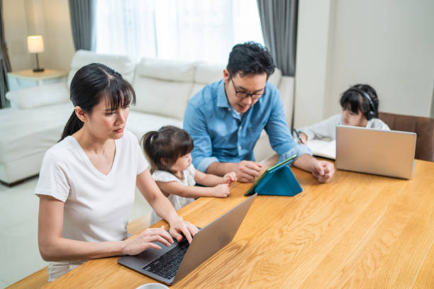 istock Asian busy family stay home during lockdown, Parents work from home using laptop for virtual video conference. Loving Father help and support little kid daughters doing onling study by remote meeting. 1319781978