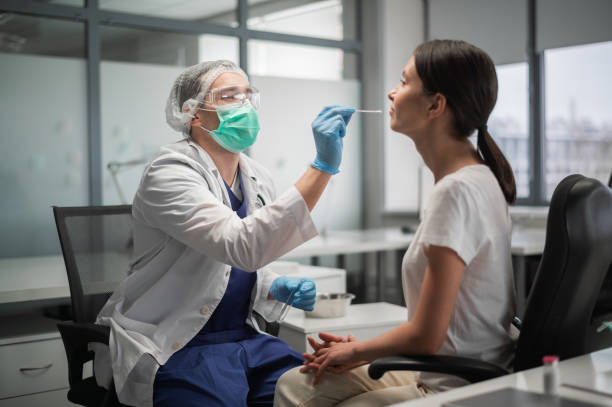 研究室では、ポリメラーゼ連鎖反応によるコロナウイルスの検査が行われ、女性患者の鼻咽頭からスミアが採取される - nasopharynx ストックフォトと画像