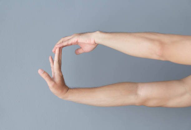 stretching exercises finger on grey background, health care and medical concept stretching exercises finger on grey background, health care and medical concept forearm stock pictures, royalty-free photos & images