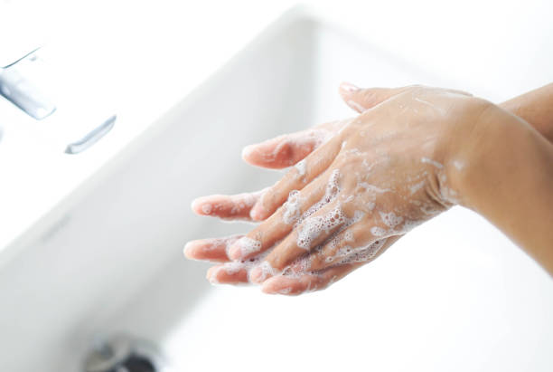 istock Closeup woman's hand washing with soap in bathroom, selective focus 1319783809