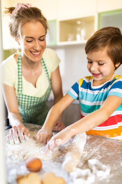 istock Boy making cookies whit his mother in the kitchen 1319784845
