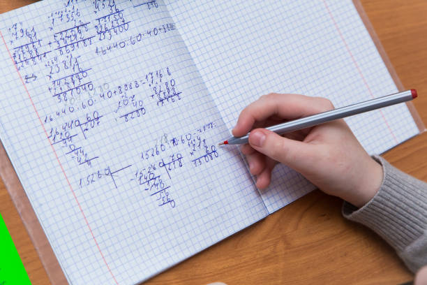 istock A girl's hand with a ballpoint pen close-up writes numbers in a notebook. 1319785191