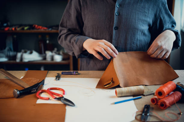 istock Desktop in the shoemaker workshop. The process of making leather shoes. Hands close-up without a face 1319788497
