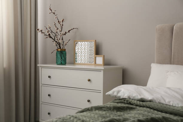 Flowering tree twigs and decor on white chest of drawers in bedroom Flowering tree twigs and decor on white chest of drawers in bedroom dresser stock pictures, royalty-free photos & images