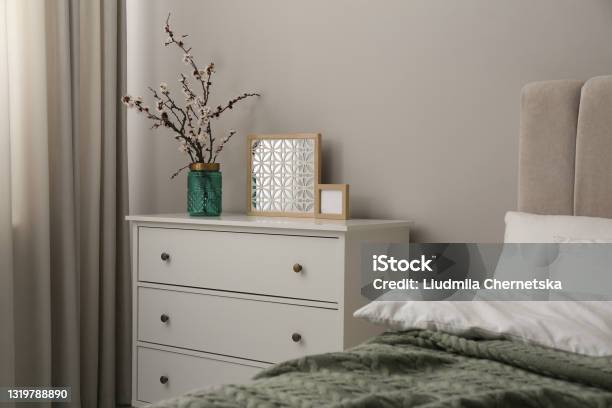 Flowering Tree Twigs And Decor On White Chest Of Drawers In Bedroom Stock Photo - Download Image Now