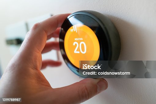 istock Regulating heating temperature with a modern smart thermostat 1319788987