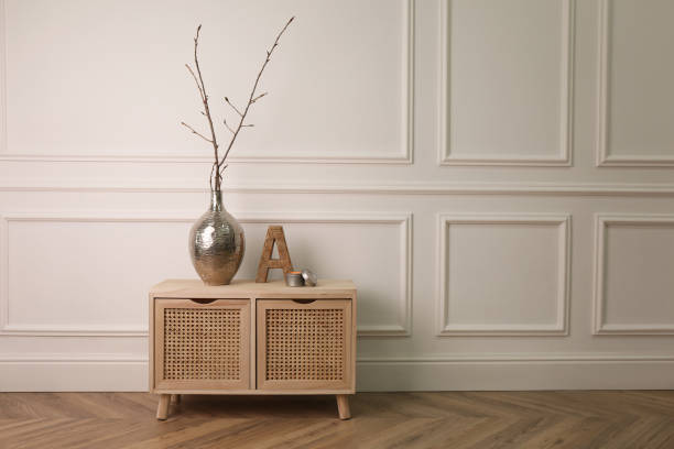 istock Tree twigs and decor on wooden table near white wall in room. Space for text 1319789401