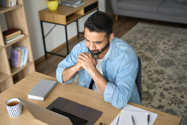 istock Top view of young indian latin student watching online webinar. 1319789970