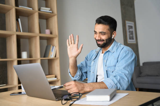 istock Young happy smiling indian man having video call at home office using pc. 1319789984
