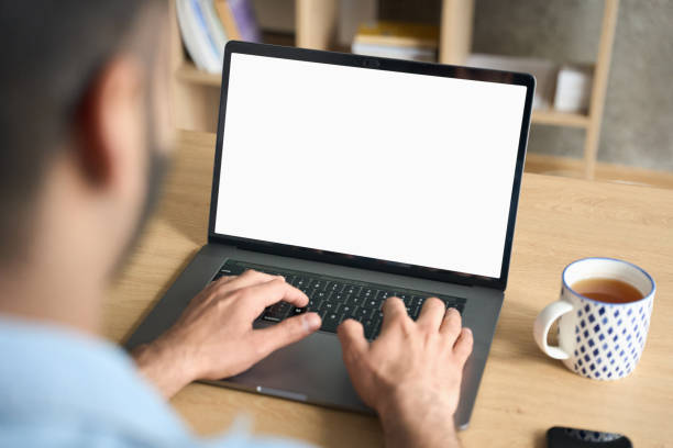 istock Indian businessman typing working using laptop at home office. Mockup screen. 1319790009