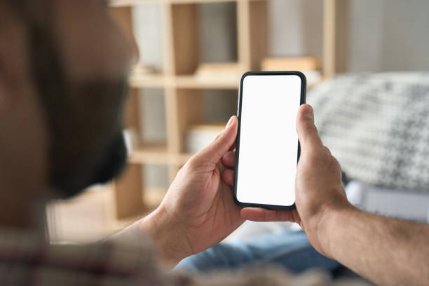 istock Male hands holding cellphone. Empty white screen. Over shoulder closeup view. 1319790037