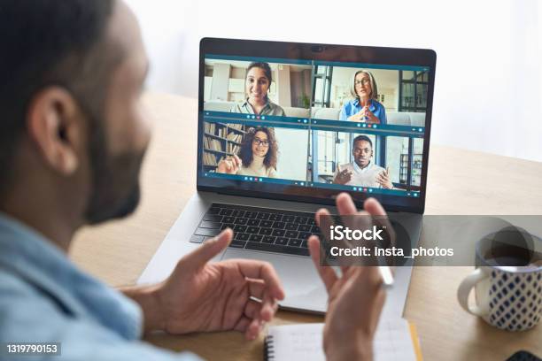 Over Shoulder View Of Indian Man Having Video Call With Diverse People On Pc Stock Photo - Download Image Now