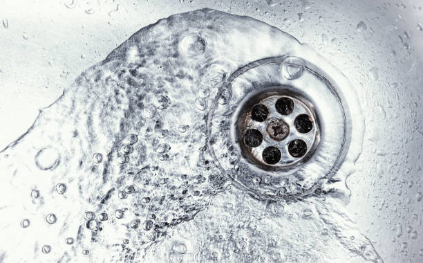 sink hole water drain down on stainless steel kitchen sink hole. top view sewer in washbasin. household plumbing. cleaning and hygiene concept. drain stock pictures, royalty-free photos & images