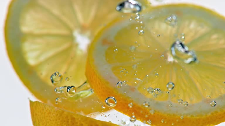 SLO MO LD Lemon slices falling into water