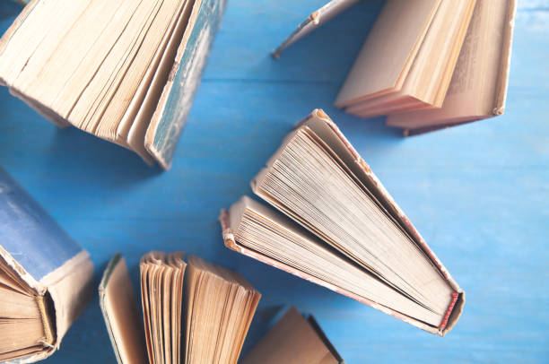 istock Old books on blue wooden background. 1319797166