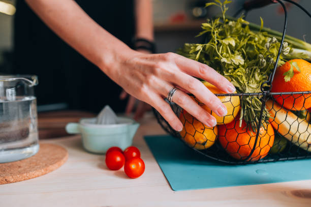 バスケットからレモンを拾う女性の手 - serving food fruit salad human hand ストックフォトと画像