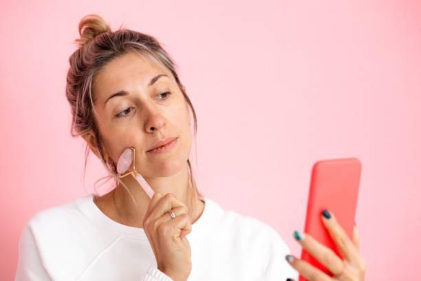 la jeune femme prend un selfie tout en massant guasha, crée le contenu pour des réseaux sociaux - massaging spa treatment stone massage therapist photos et images de collection