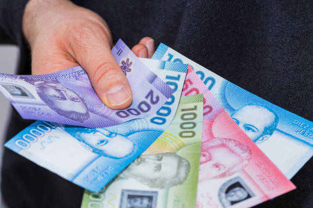 istock Chilean Banknotes, Different Values, Money spread out and held in the hand 1319798623