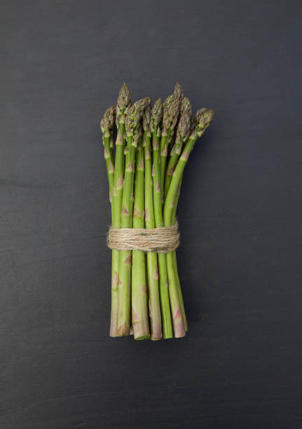 istock Fresh green asparagus on black background. Top view. 1319798757