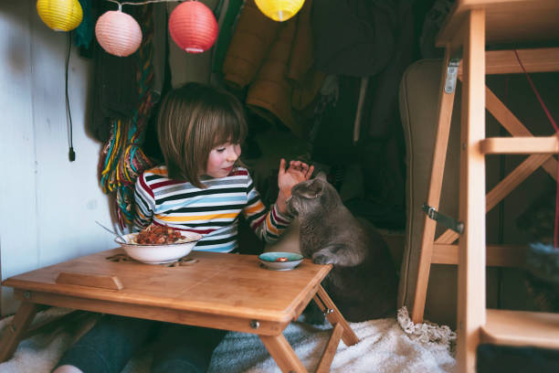 istock Happy little boy eating spaghetti with his cat 1319798792