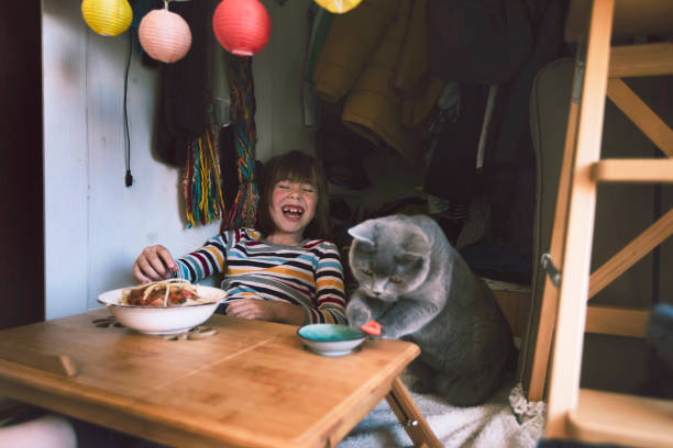 istock Happy little boy eating spaghetti with his cat 1319799476