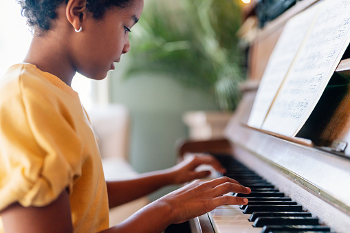Educación musical. Chica negra feliz tocando el piano photo