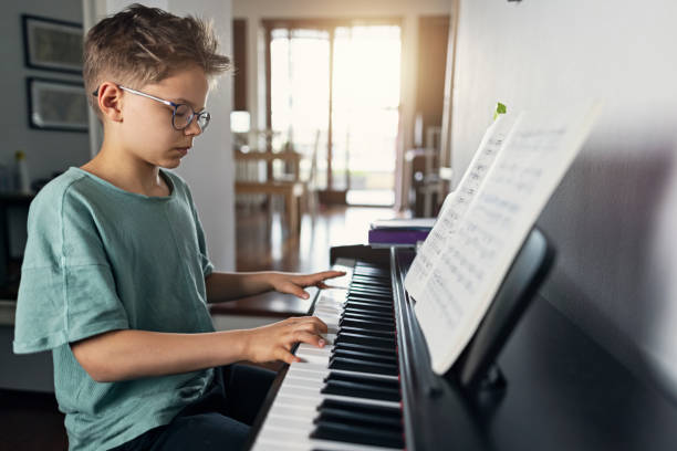 teenage boy playing digital piano - practicing piano child playing imagens e fotografias de stock