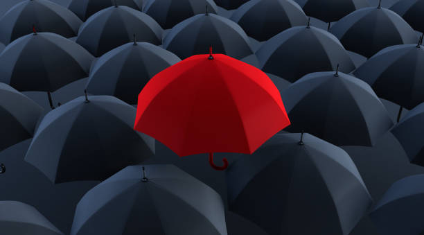 istock 3d render of Unique red umbrella among many dark ones. 1319801437
