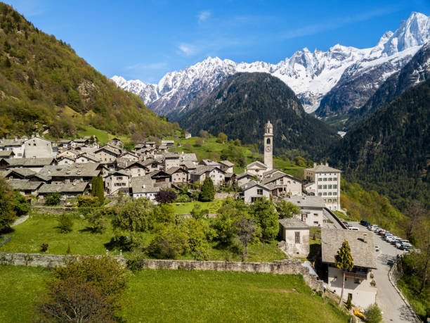 luftbild des schweizer bergdorfes soglio mit dem schneebedeckten sciora-gebirge - engadine built structure house mountain stock-fotos und bilder