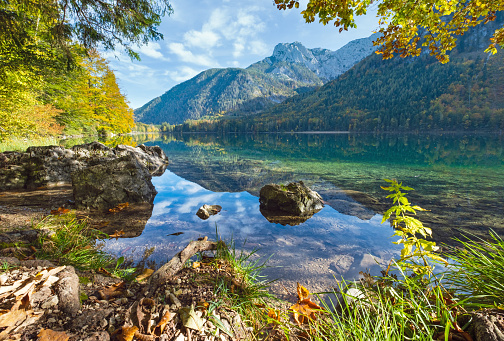 Sunny idyllic colorful autumn alpine view. Peaceful mountain lake with clear transparent water and reflections. Langbathseen lake, Upper Austria.