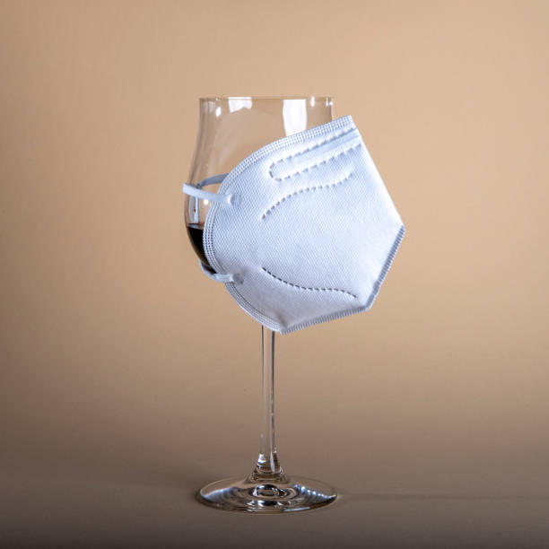 istock wine glass with red wine and a ffp2 face mask, beige background 1319806061