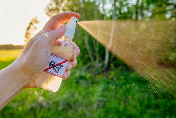 zbliżenie na kobietę trzymającą rękę i używającą domowego olejku na bazie komarów na zewnątrz w lesie. - insect repellant zdjęcia i obrazy z banku zdjęć