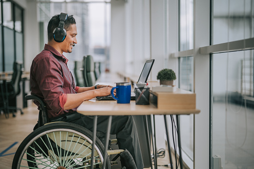 trabajador asiático de cuello blanco indio con discapacidad en silla de ruedas hablando con la cámara videollamada videoconferencia con sus socios comerciales photo