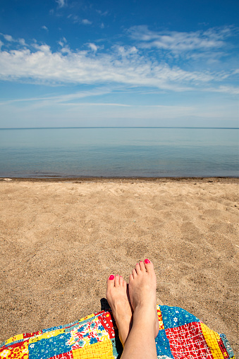 A woman's feet on a blanket on the beach of Lake Erie.