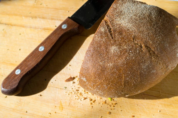 istock Fresh rye bread and a knife on the table with crumbs 1319813592