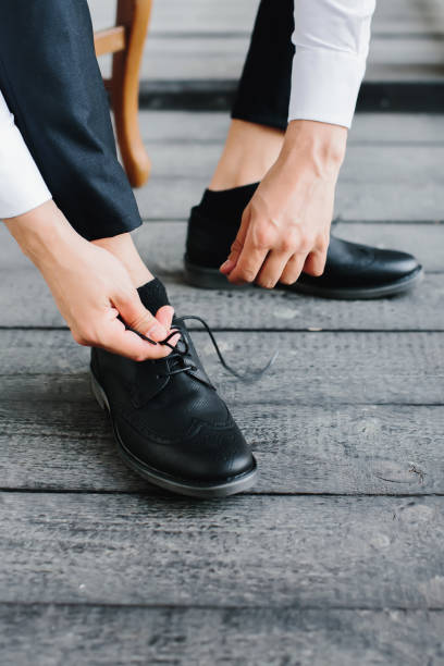 młody mężczyzna zakłada czarne buty i krawaty sznurowadła, zbliżenie męskich rąk. selektywne skupienie. - 4592 zdjęcia i obrazy z banku zdjęć