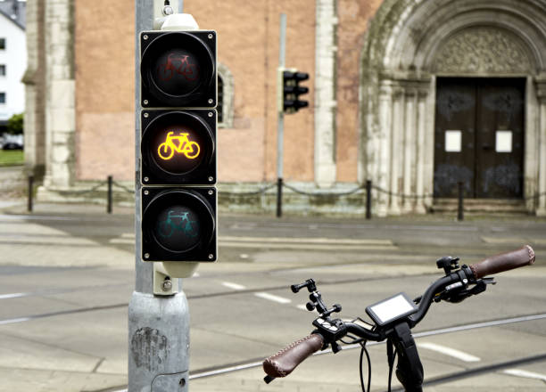 istock Bicycle handlebars next to a traffic light for bicycles showing a yellow light, concept for bicycle tour in the city center 1319814927