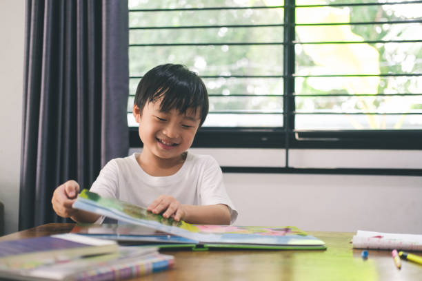 istock Happy boy when reding a picture book at home. 1319816571