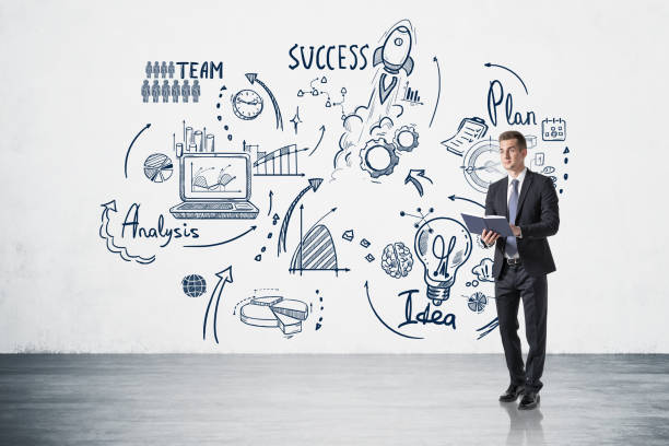 istock Businessman with notebook and business strategy sketch on concrete wall 1319816632