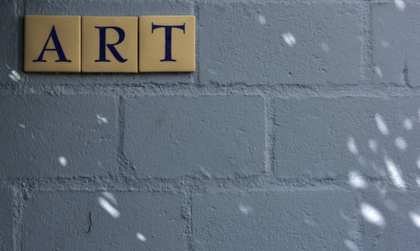 istock Sun specks adding a special touch to a blue backdrop wall with the word ART spelled out in tiles on it 1319816651