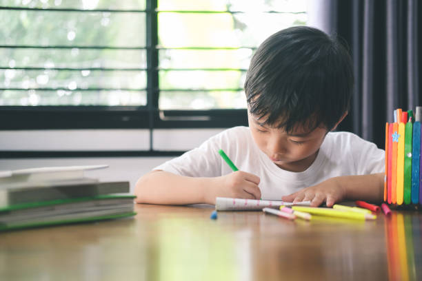 istock Kindergarten boy drawing and learning at home. 1319816693