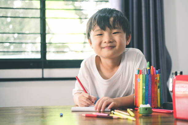 istock Happy kindergarten boy drawing and learning at home. 1319816694