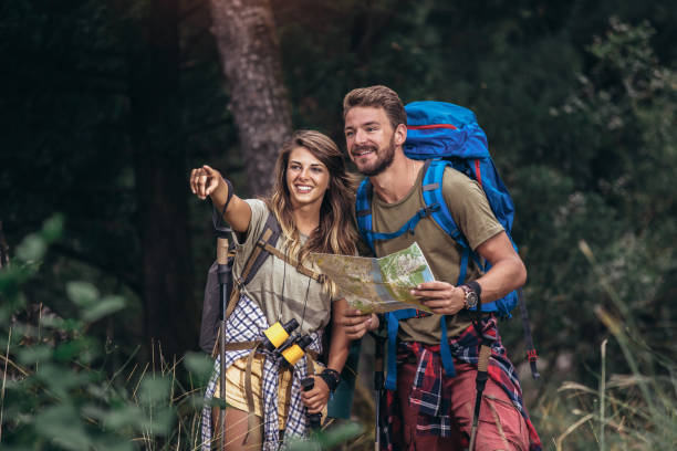 istock Couple hiking trough forest. Using map to get good direction. 1319819040