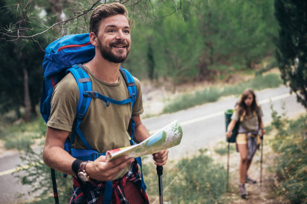 istock Couple hiking trough forest. Using map to get good direction. 1319820581