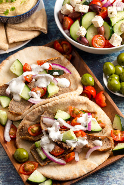 istock Two Gyros with Vegetables and White Garlic Sauce on a Rustic Wooden Table 1319820699
