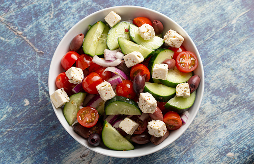 A Bowl of Fresh Greek Salad with Cucumbers Tomatoes Olives and Feta Cheese