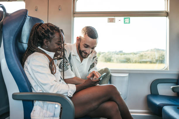 istock Couple traveling by train and texting on mobile during the journey 1319823428