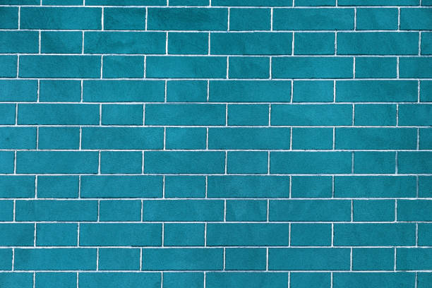 istock Brick wall is bright blue colored, texture of stone blocks, background of bricks. 1319823432