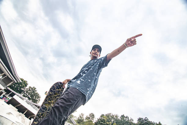 istock Asian skateboarder standing and looking away at skateboard park 1319824568